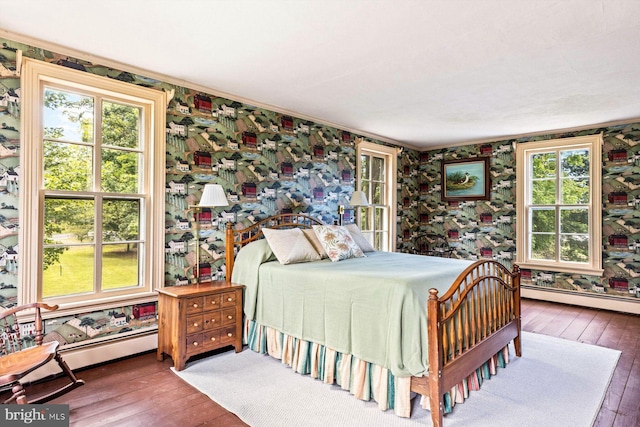 bedroom with hardwood / wood-style floors and baseboard heating