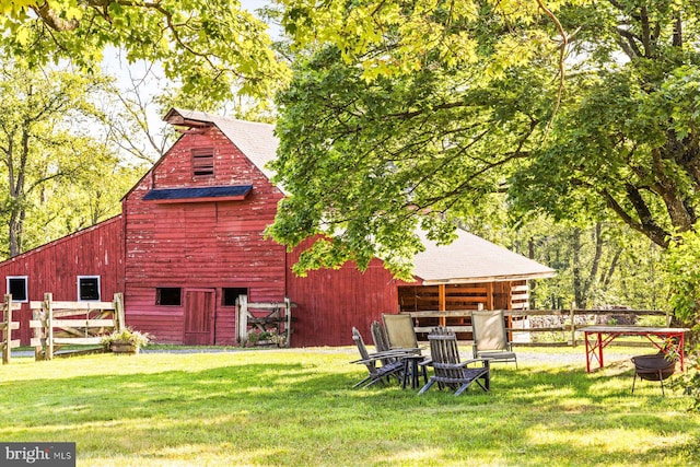 back of house featuring an outdoor structure and a lawn