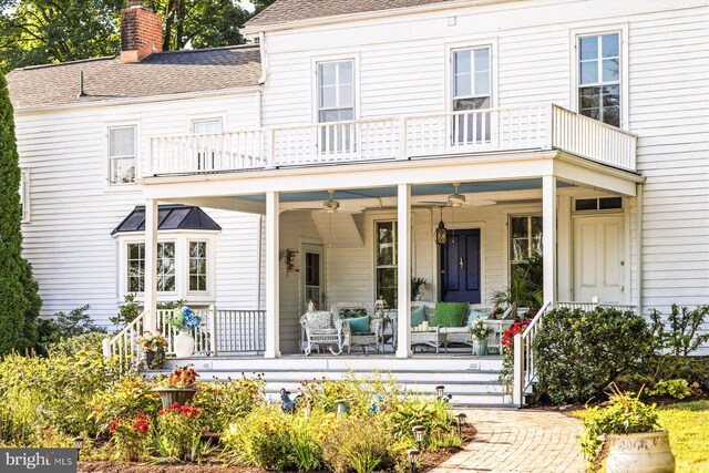 back of property featuring a porch, a balcony, and ceiling fan