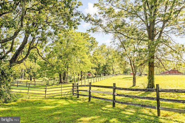 view of gate featuring a rural view and a lawn