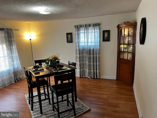 dining area with a textured ceiling and hardwood / wood-style flooring