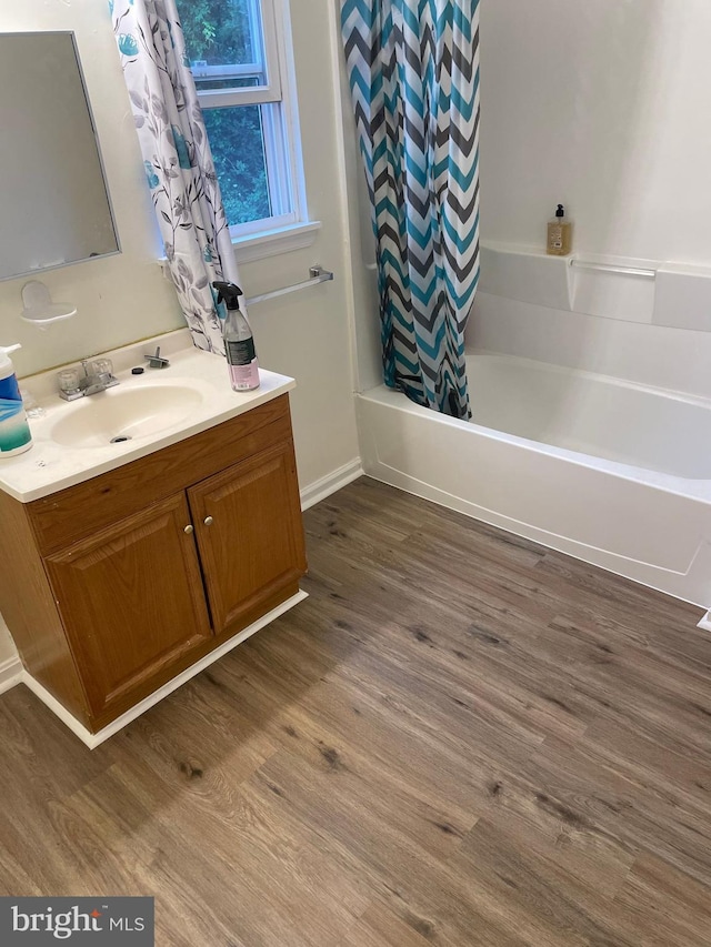 bathroom featuring vanity, wood-type flooring, and shower / bath combo with shower curtain