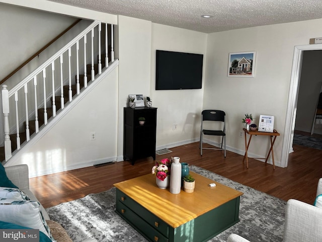 living room featuring dark hardwood / wood-style flooring and a textured ceiling