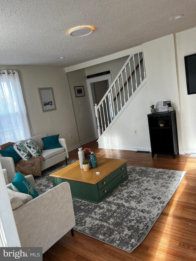 living room featuring a textured ceiling and dark hardwood / wood-style flooring