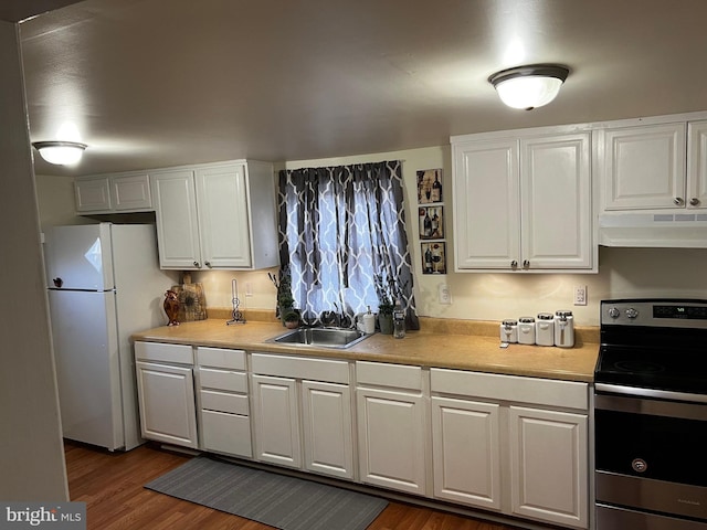 kitchen featuring stainless steel electric range, white cabinetry, and sink