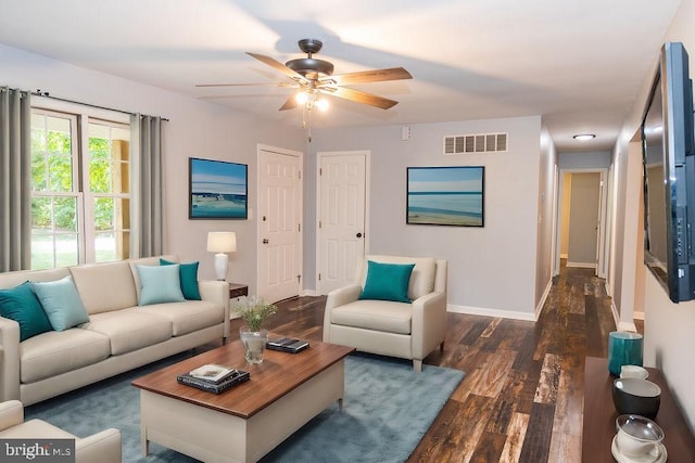 living room with ceiling fan and dark wood-type flooring