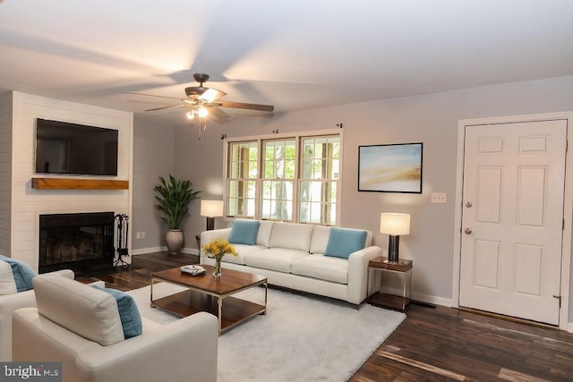 living room with ceiling fan, dark hardwood / wood-style floors, and a fireplace