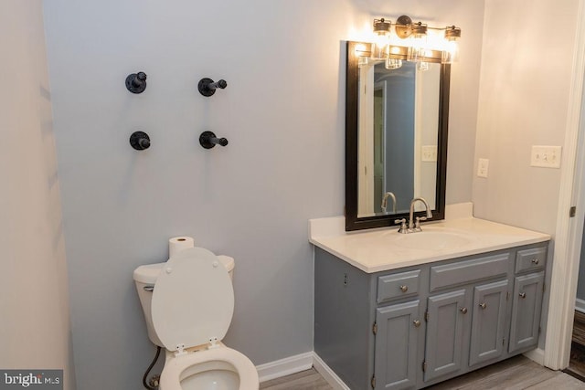 bathroom featuring hardwood / wood-style flooring, vanity, and toilet