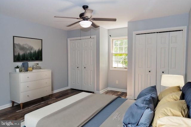 bedroom featuring ceiling fan, dark wood-type flooring, and two closets