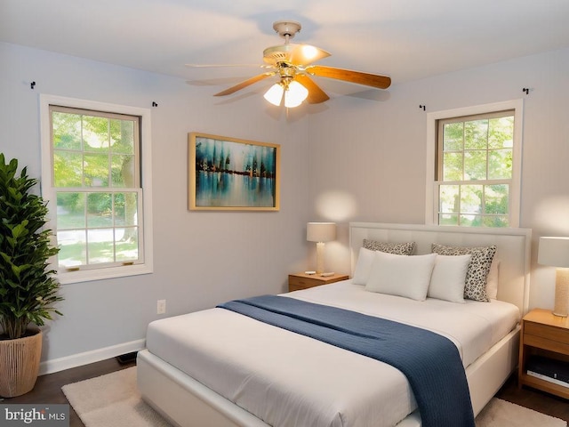 bedroom featuring multiple windows, ceiling fan, and dark wood-type flooring