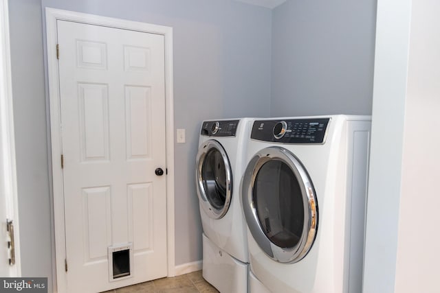 laundry room featuring washer and clothes dryer and light tile patterned flooring