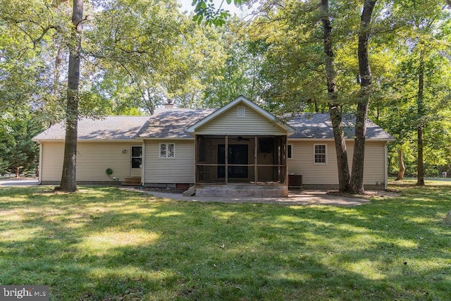 rear view of house featuring a patio, a lawn, and a sunroom