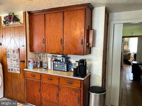 kitchen featuring wood walls, washer / dryer, and a textured ceiling