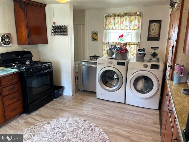 laundry room with washing machine and dryer and light hardwood / wood-style floors