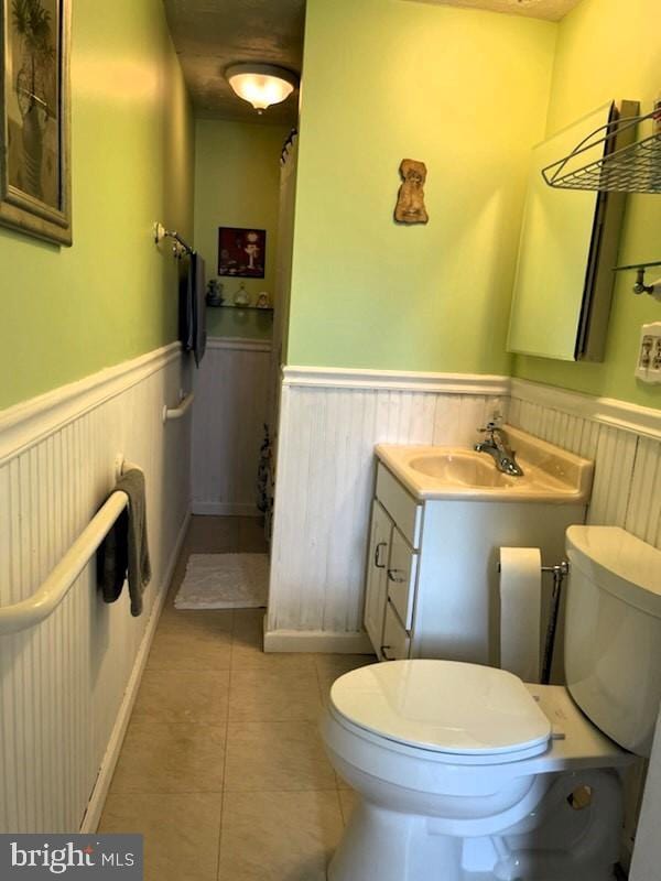 bathroom featuring tile patterned flooring, vanity, toilet, and a textured ceiling