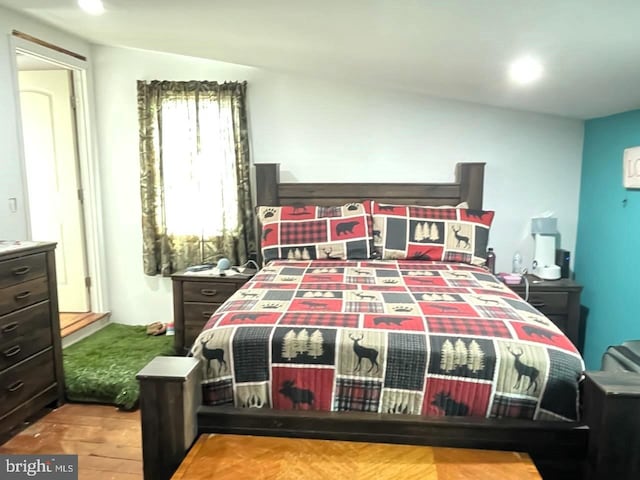 bedroom featuring light wood-type flooring and lofted ceiling