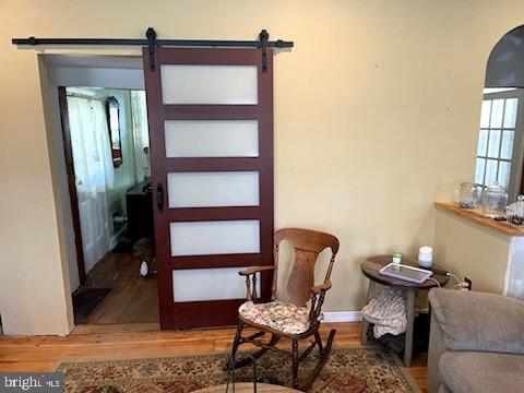 living area featuring a barn door and hardwood / wood-style floors