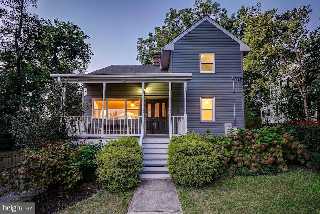 traditional home with a chimney and a porch