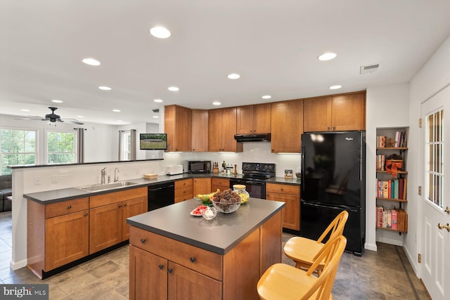 kitchen with ceiling fan, sink, a center island, kitchen peninsula, and black appliances