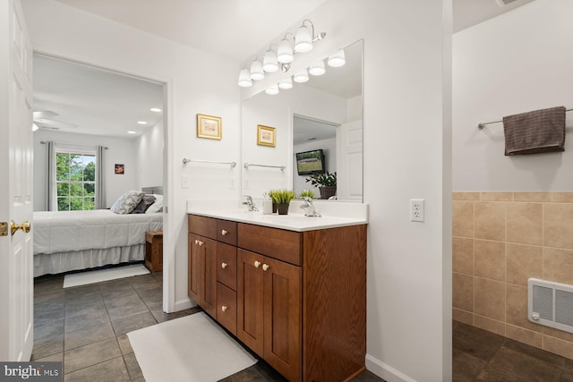 bathroom featuring ceiling fan, tile patterned flooring, vanity, and tile walls