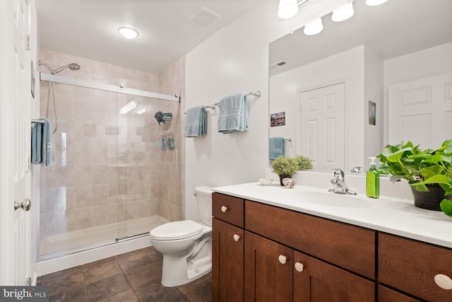 bathroom with vanity, an enclosed shower, and toilet