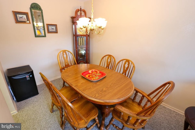 dining room with carpet and an inviting chandelier