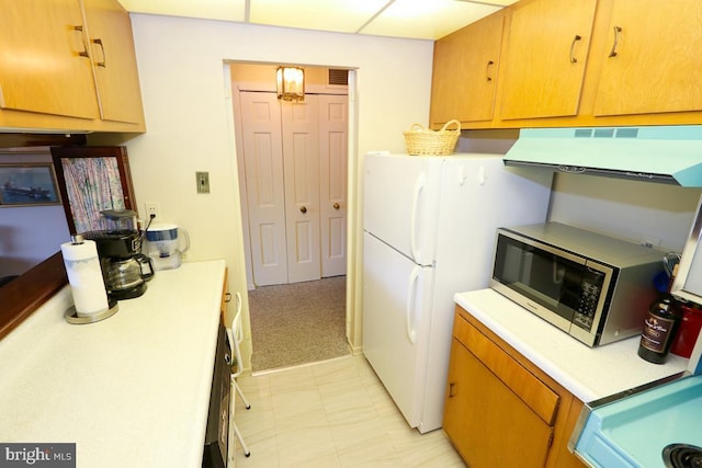 kitchen with light colored carpet, white fridge, and exhaust hood