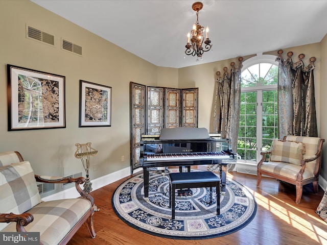 sitting room featuring wood-type flooring and a notable chandelier