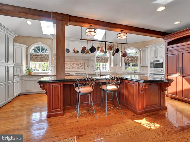 kitchen with pendant lighting, decorative backsplash, a center island, and white cabinetry