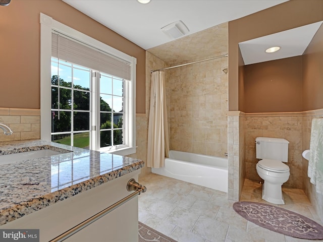 full bathroom featuring shower / bath combo, toilet, tile walls, and sink