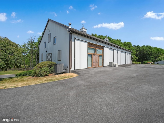 exterior space with central AC and a garage