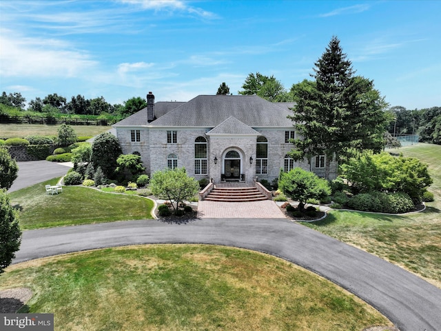 french country home featuring a front lawn