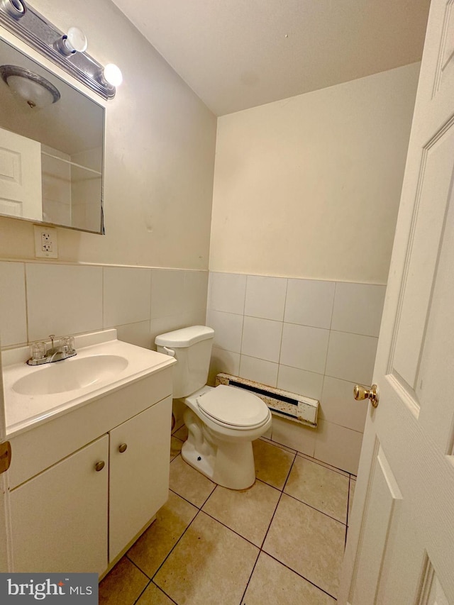 bathroom with vanity, tile patterned flooring, toilet, tile walls, and a baseboard radiator