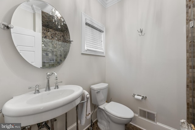 bathroom with crown molding, toilet, and sink