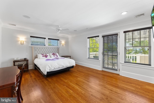 bedroom featuring hardwood / wood-style flooring, ornamental molding, and ceiling fan