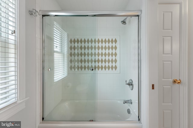 bathroom featuring a wealth of natural light and combined bath / shower with glass door