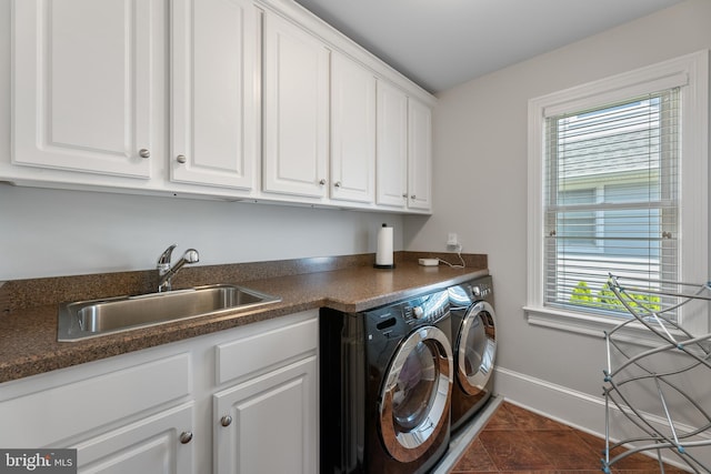 washroom featuring cabinets, a healthy amount of sunlight, sink, and washer and dryer