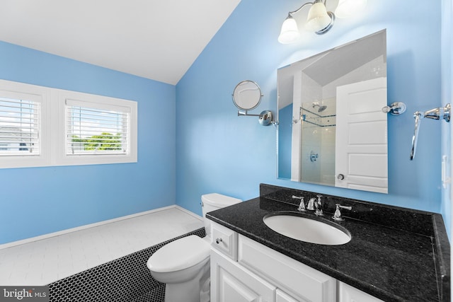 bathroom featuring vanity, toilet, vaulted ceiling, and a shower