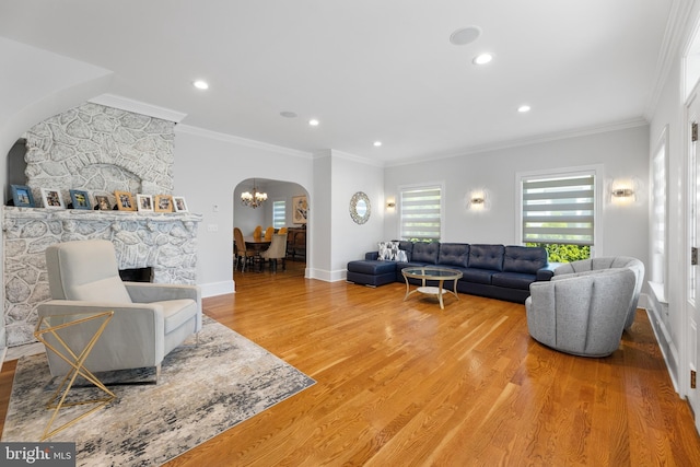 living room featuring wood-type flooring, a chandelier, and crown molding