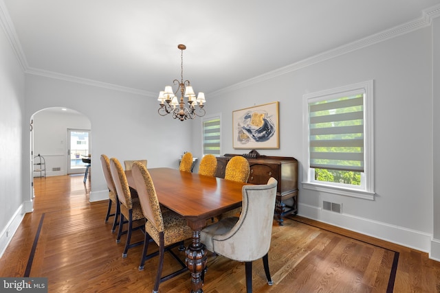 dining room featuring a notable chandelier, hardwood / wood-style flooring, and ornamental molding