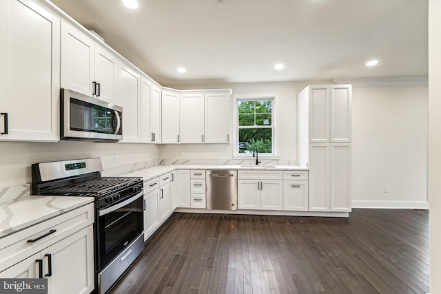 kitchen featuring light stone countertops, appliances with stainless steel finishes, white cabinetry, sink, and dark hardwood / wood-style floors