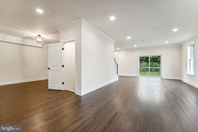 unfurnished room with dark wood-type flooring, ornamental molding, and a chandelier