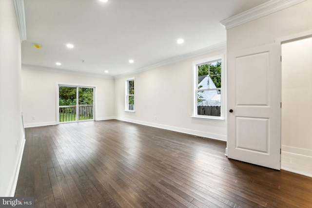 empty room featuring dark wood-type flooring, a wealth of natural light, and crown molding