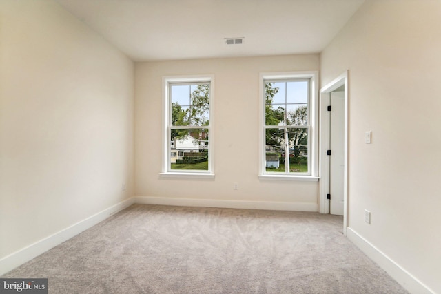 spare room featuring light carpet