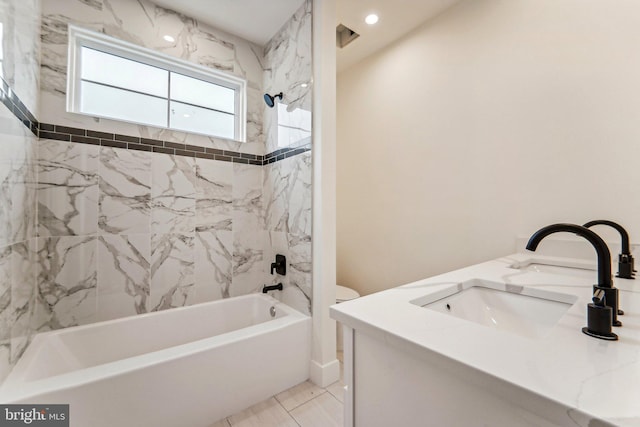 bathroom featuring tile patterned floors, tiled shower / bath combo, and vanity