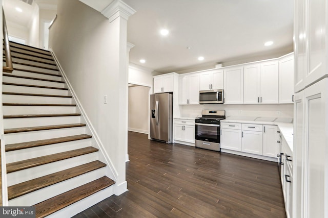 kitchen featuring white cabinets, appliances with stainless steel finishes, and dark hardwood / wood-style flooring