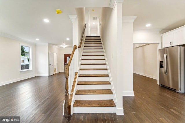 stairway with crown molding and hardwood / wood-style floors