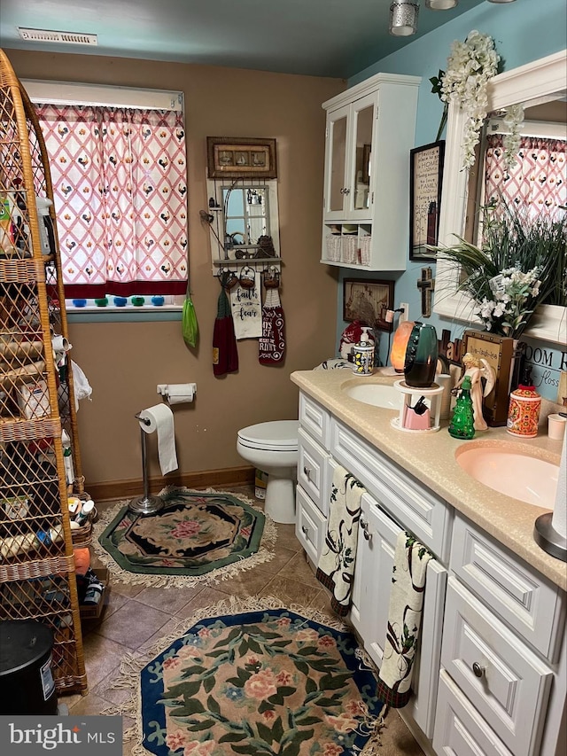 bathroom with tile patterned flooring, vanity, and toilet