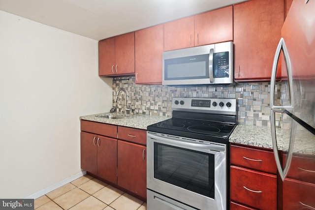 kitchen featuring decorative backsplash, light tile patterned floors, sink, and appliances with stainless steel finishes