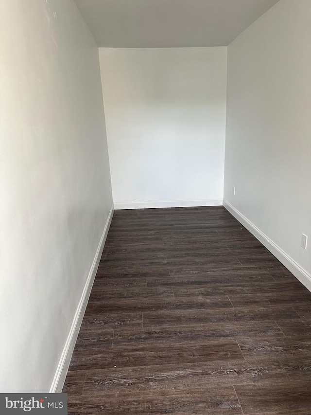 empty room with dark hardwood / wood-style flooring